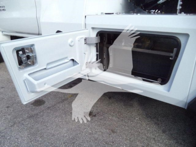 Truck rear storage area with open side compartment and silver latch, showing interior cavity