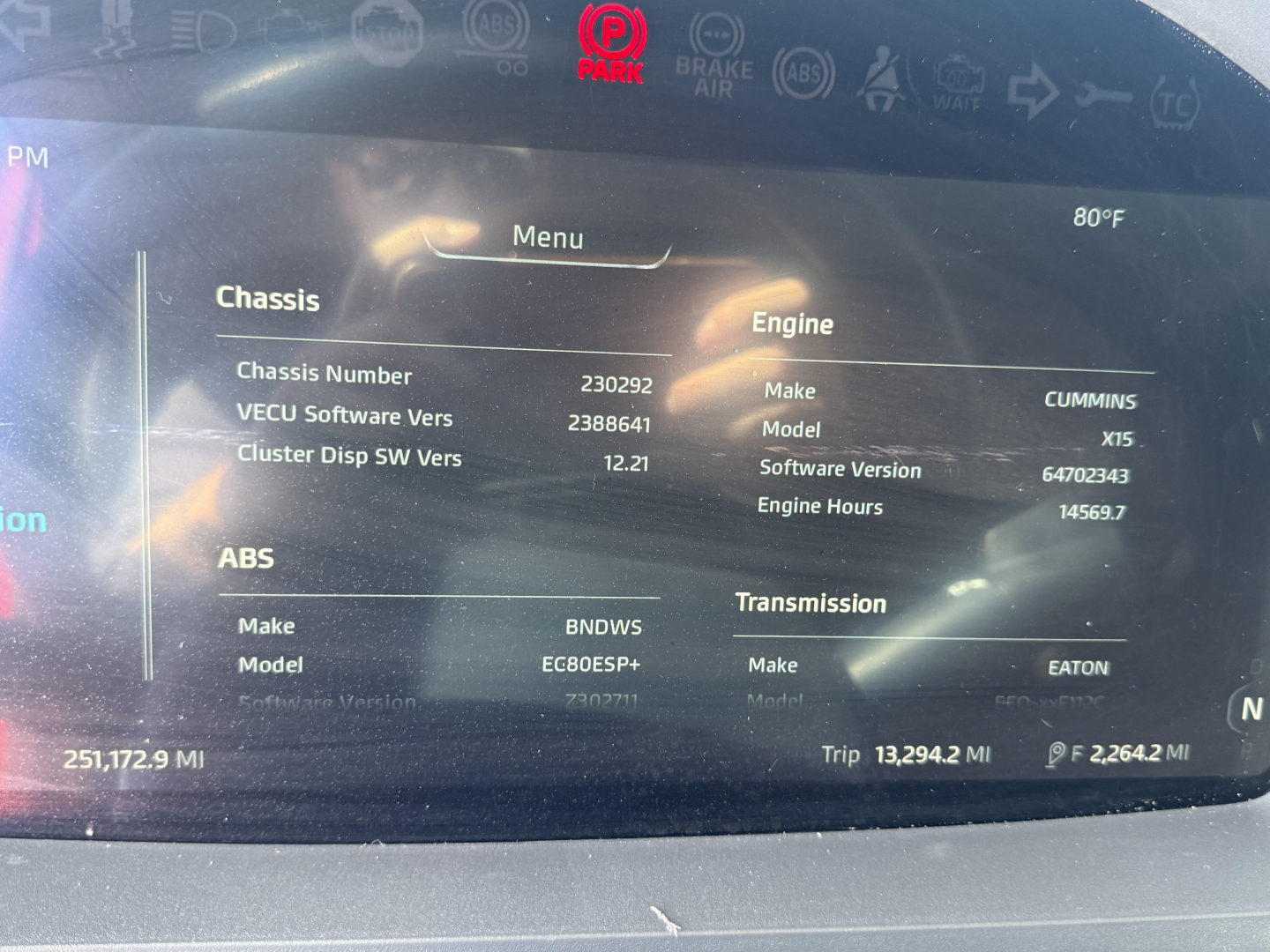 Kenworth T680 instrument cluster display showing vehicle information: Chassis numbers, engine make/model Cummins ISX, software/software version, ABS, transmission, trip mileage 13,294.2 mi, engine hours 145,697, chasis number 230292.