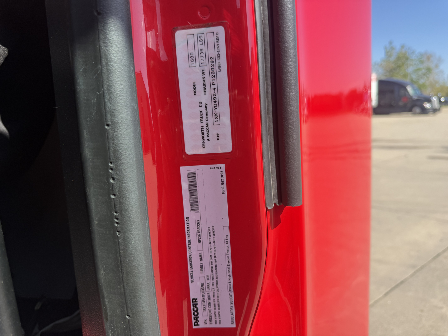 Kenworth T680 door jamb with VIN/stock tag and guide labels showing barcodes and text.