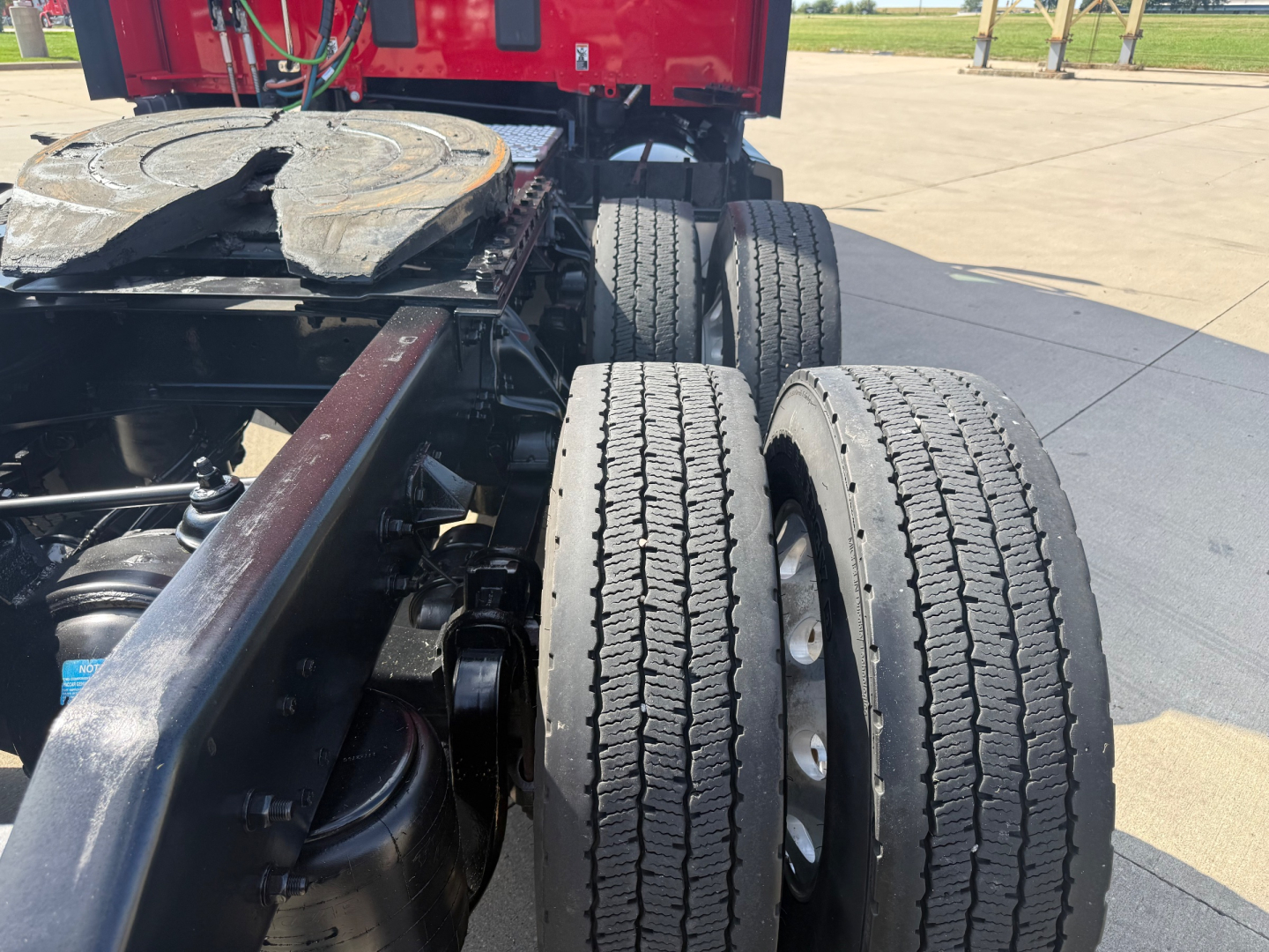Kenworth T680 truck chassis showing dual rear axles with dual tires and fifth wheel, undercarriage, and frame near cab; part of tractor unit.