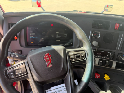 Kenworth T680 interior steering wheel and dashboard with digital display and controls.