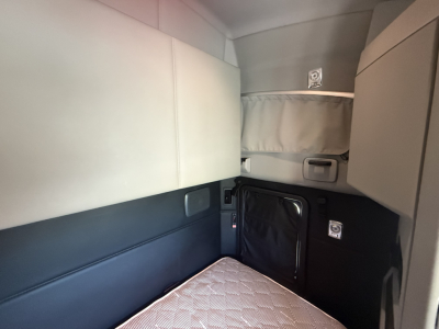Kenworth T680 sleeper cab interior showing bunk area and side storage pockets.