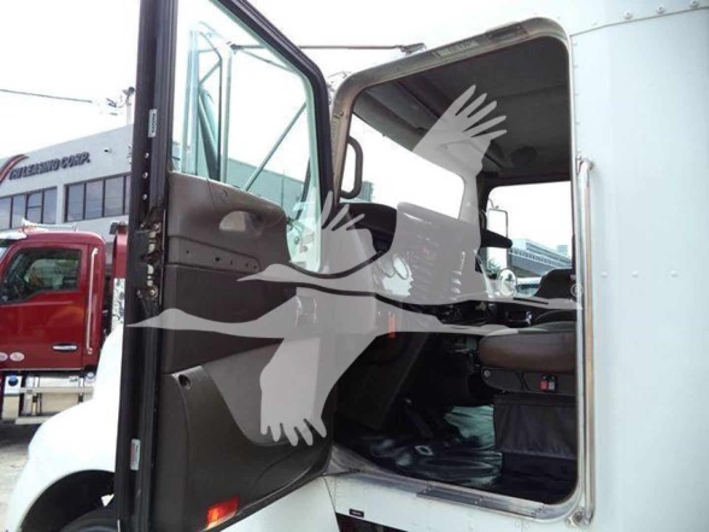 Kenworth T270 cab interior with door open, visible steering wheel and seating area; service/utility truck exterior in white.