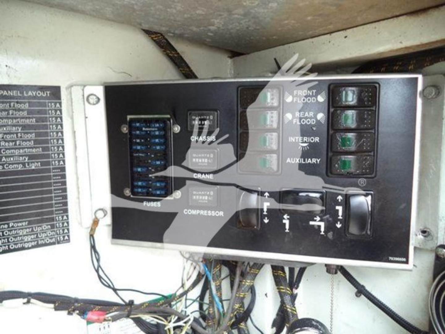Kenworth T270 service truck engine bay control panel with labeled switches and fuse panel; visible text includes FUSES, COMPRESSOR, CRANE, FRONT FLOOD, REAR FLOOD, INTERIOR, AUXILIARY, and a layout diagram; small label on left lists panel l