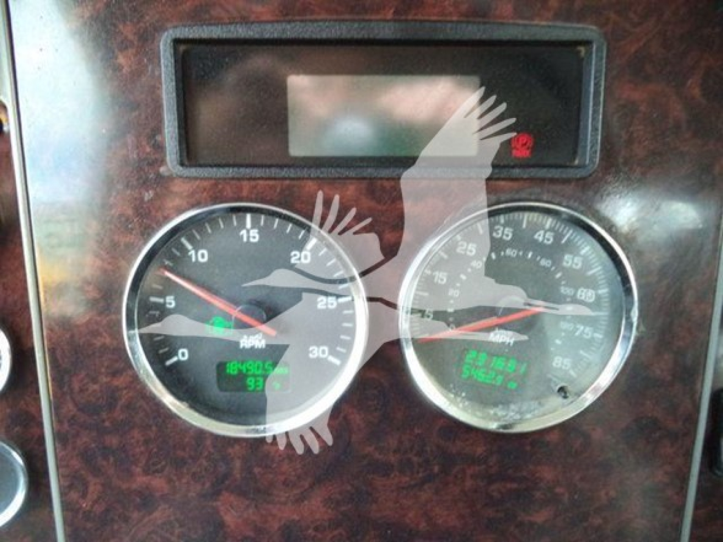 Kenworth T270 instrument cluster dashboard with two round gauges and a digital display in the center, wood-toned dashboard trim visible.
