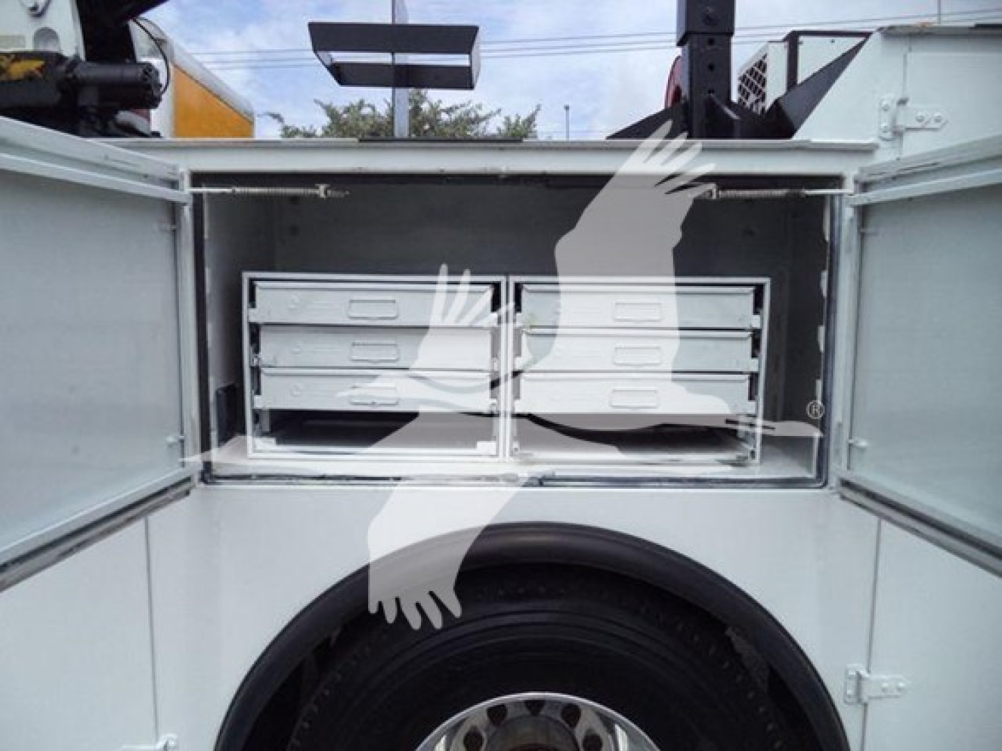 Open storage compartments on Kenworth T270 with multiple slide-out drawers in a service body and visible wheel well.