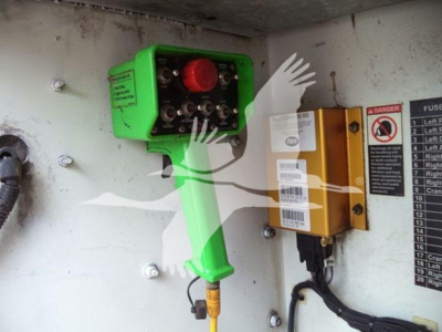 Kenworth T270 service truck rear interior showing a green control box with red knob, a yellow safety switch, and warning labels on the wall.