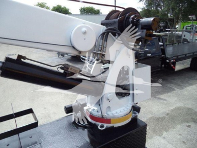 Hydraulic articulating crane on a Kenworth truck with white/yellow base and black hydraulic cylinder visible.