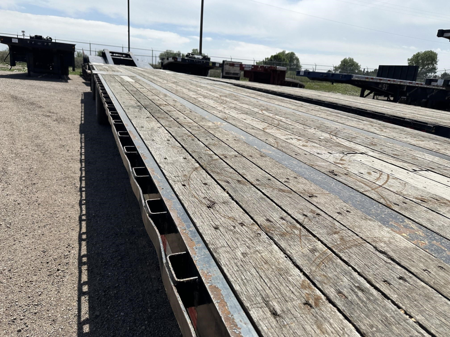 Great Dane spread air steel drop deck trailer showing wood deck planks and metal frame.