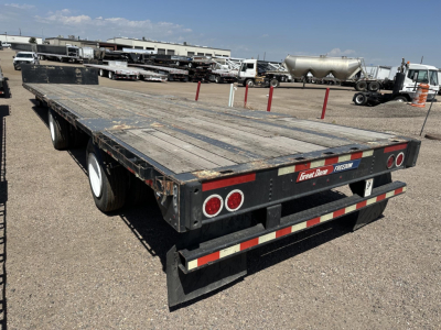 Great Dane spread air steel drop deck trailer with wood deck, rear view showing dual axles, taillights, and reflective tape.