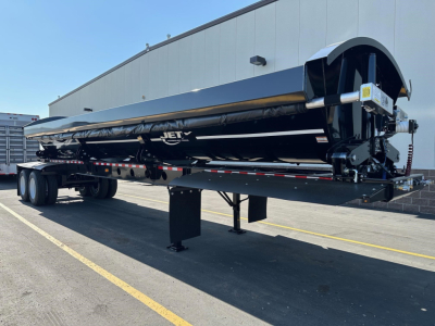 Jet Tandem Air Ride Side Dump trailer on a dual axle trailer with hydraulic components and support legs, black finish, company logo visible