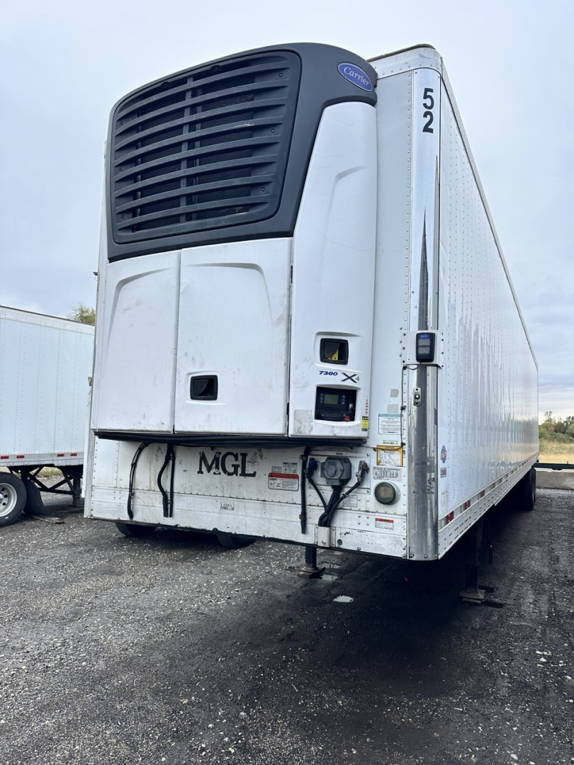 Trail King utility trailer with a Thermo King unit on the front, rear view showing hydraulic connections and bumper on a gravel lot.