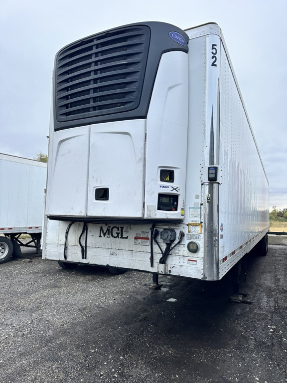 Trail King utility trailer with a Thermo King unit on the front, rear view showing hydraulic connections and bumper on a gravel lot.