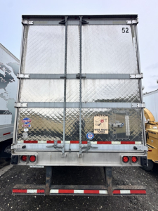 Rear view of a used 2019 Trail King utility trailer with diamond plate metal exterior, dual rear doors, lights, and registration/tail-area details visible.