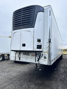 Trail King utility trailer with a Thermo King unit on the front, rear view showing hydraulic connections and bumper on a gravel lot.