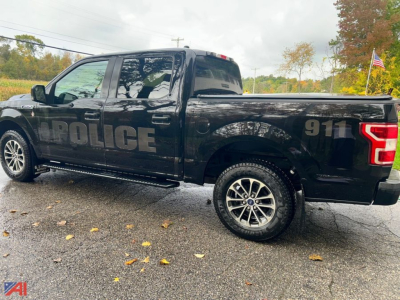 Ford F-150 police pickup truck side view showing police decal and 911 markings