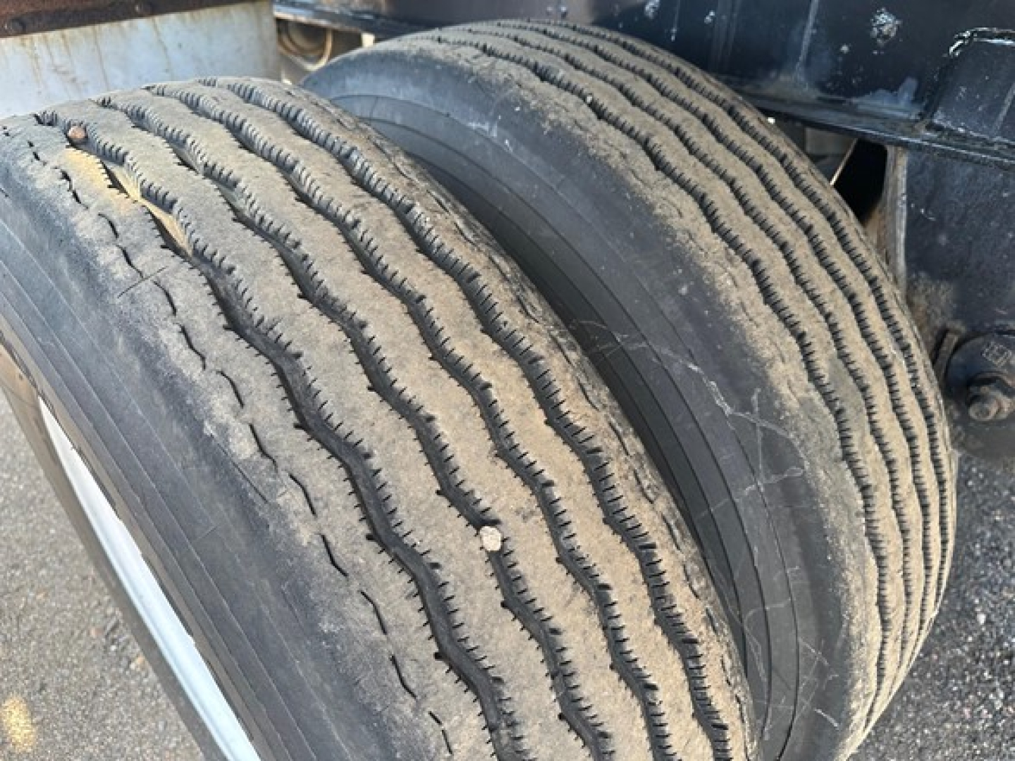 Trailer wheel pair with treaded tires, close-up view of rear axle on Fontaine Infinity flatbed trailer showing dual tires and wheel hub area.