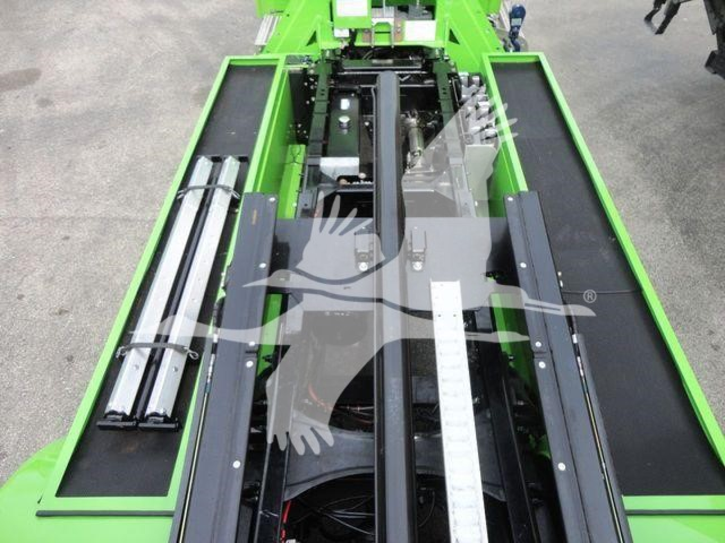 Green rollback tow truck chassis with rails and hydraulic system, side rails and measurement ruler visible