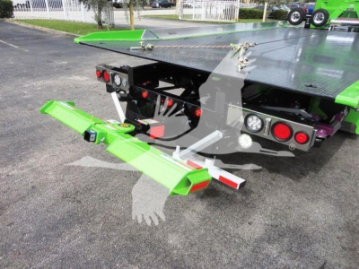 Green rollback tow platform mounted on a 2022 Peterbilt 337 showing rear view with extendable tow arm and taillights.