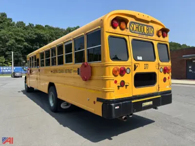 Yellow school bus rear-left side view showing 'SCHOOL BUS' sign, bus number 377, and Central School District markings along the side; black bumper and rear lights.
