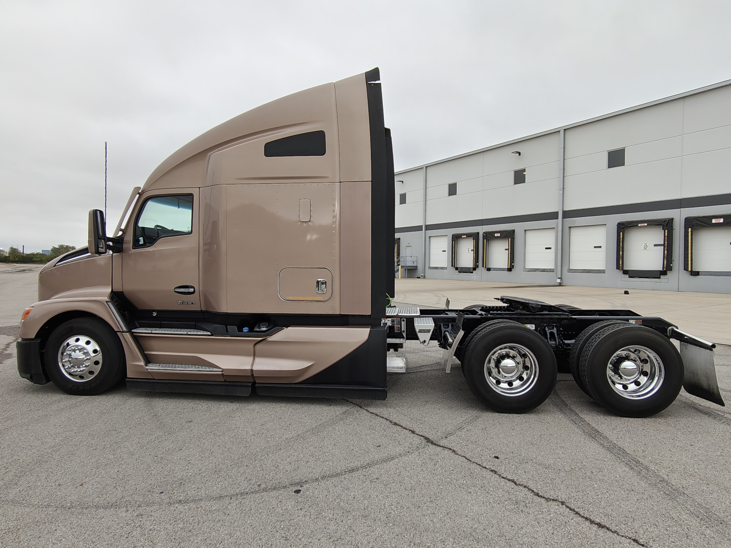 Kenworth T680 tractor in beige showing side profile with sleeper cab and chassis, no trailer attached.