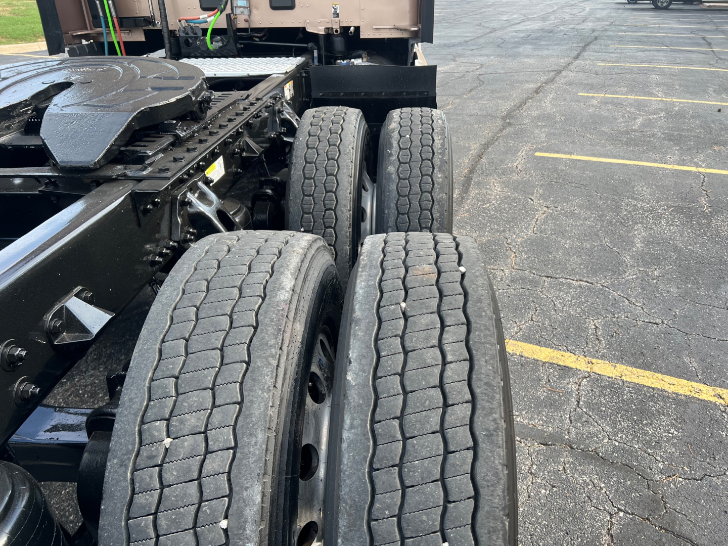 Kenworth T680 truck chassis with dual rear axles and tires in view; part of the frame and fifth wheel visible; no text readable