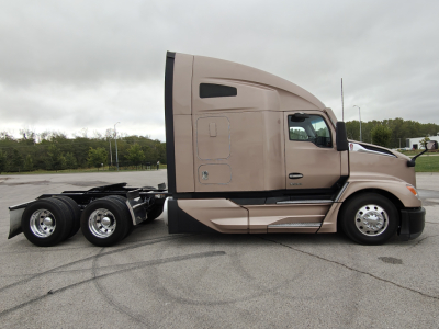 Kenworth T680 tractor cab side view showing fuel/air tanks and rear wheels.