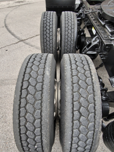 Kenworth T680 rear dual-axle configuration with four tires visible and drivetrain components in view.