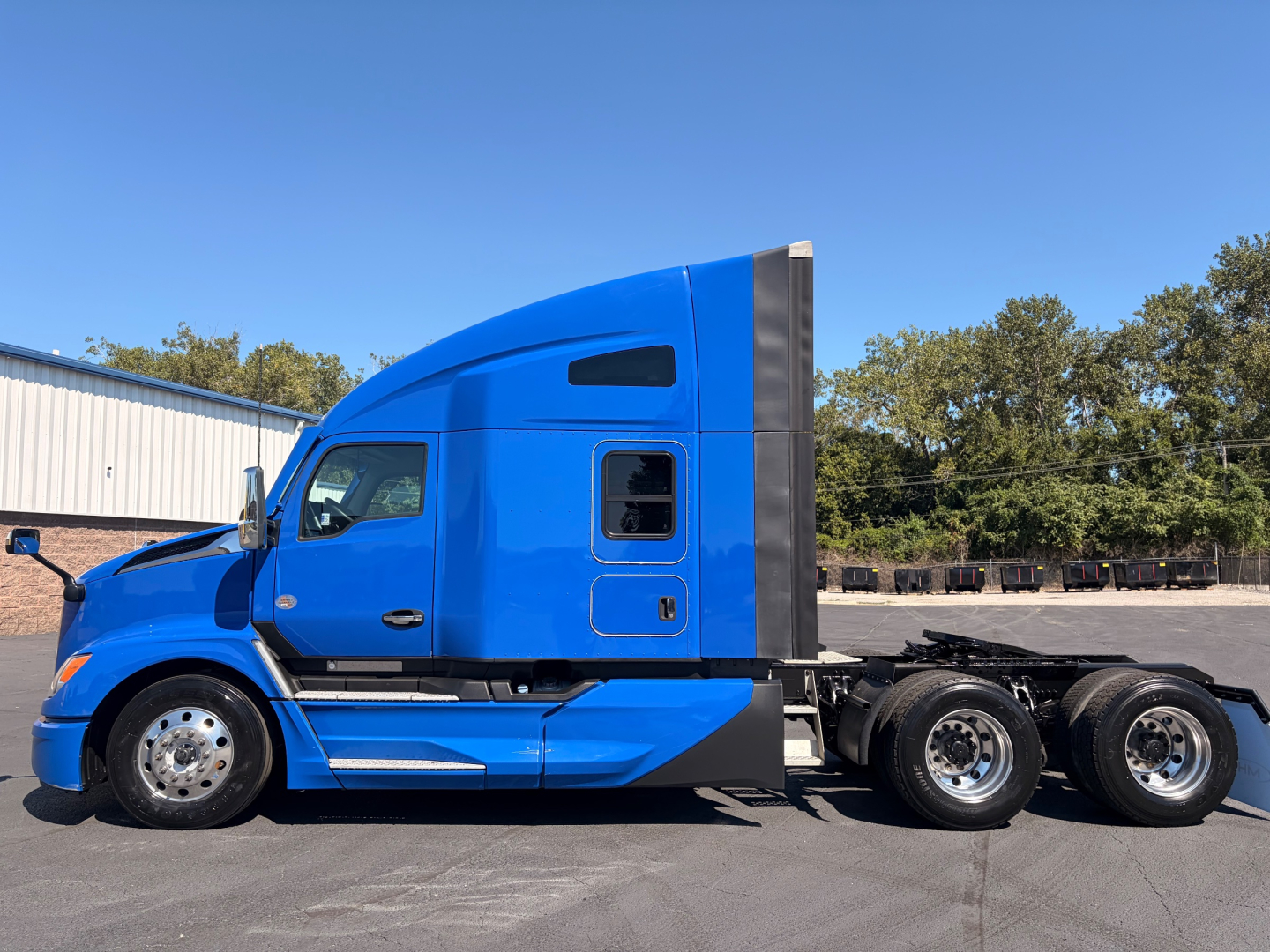 Kenworth T680 tractor side view showing blue sleeper cab and rear wheels.