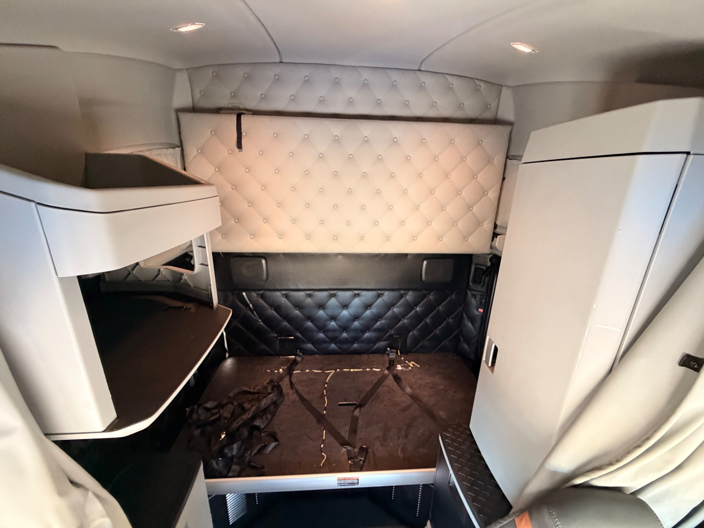 Kenworth T680 sleeper cab interior showing Diamond-stitched headboard and side storage compartments.
