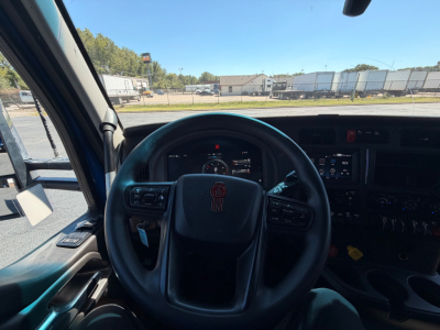 Kenworth T680 steering wheel and dashboard view inside cab showing gauges and controls.