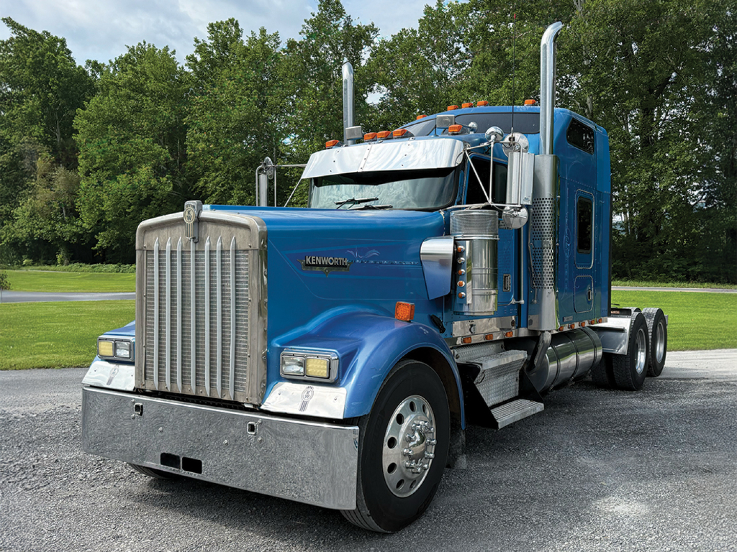 Kenworth W900L AeroCab conventional sleeper truck front-left view with chrome accents and blue paint.