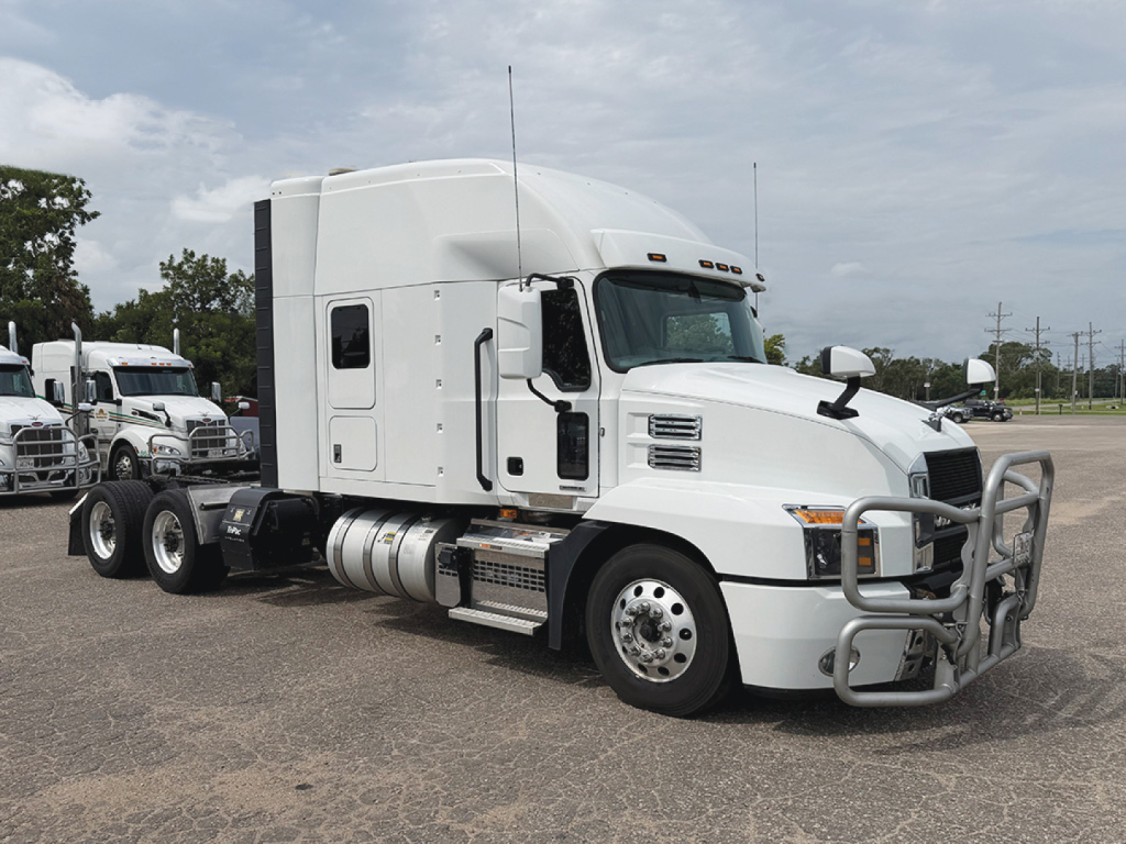 Mack Anthem semi-truck tractor in white, side view showing sleeper cab, front bull bar, fuel tanks, and 3-axle chassis.