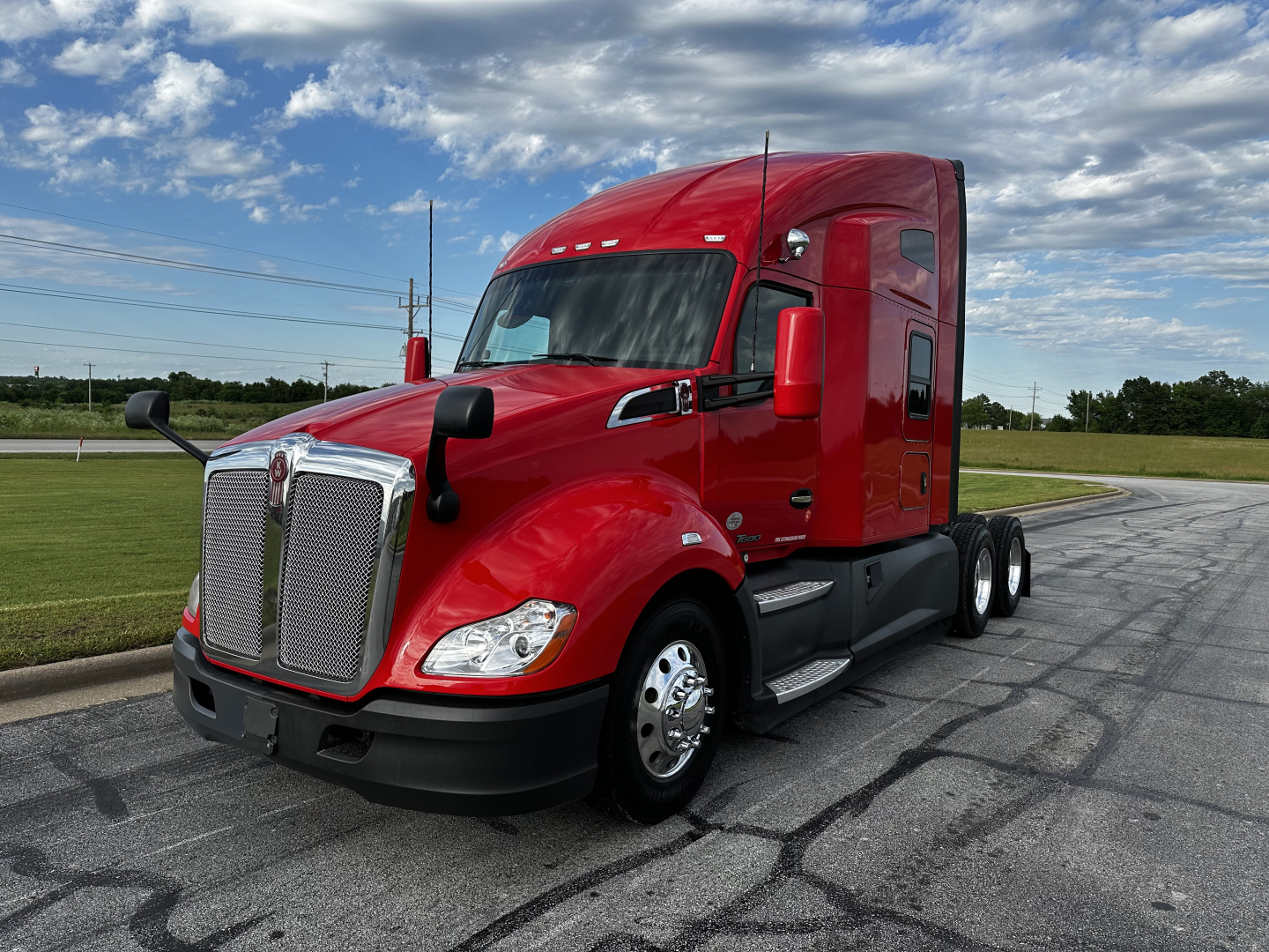 Kenworth T680 semi truck in red, side view showing sleeper cab and front grille.