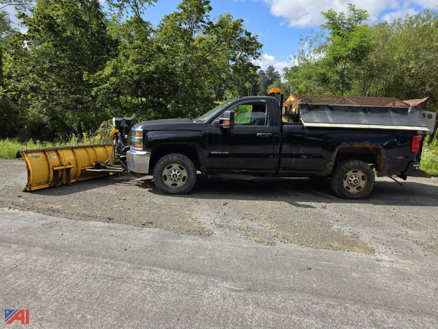 Chevrolet Silverado 2500HD 4x4 pickup with snow plow and snow/dump bed, front view showing plow blade attached to a black extended cab truck
