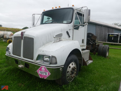 Kenworth T300 chassis showin g front view with white cab and pink hazardous material placard 1075 on bumper
