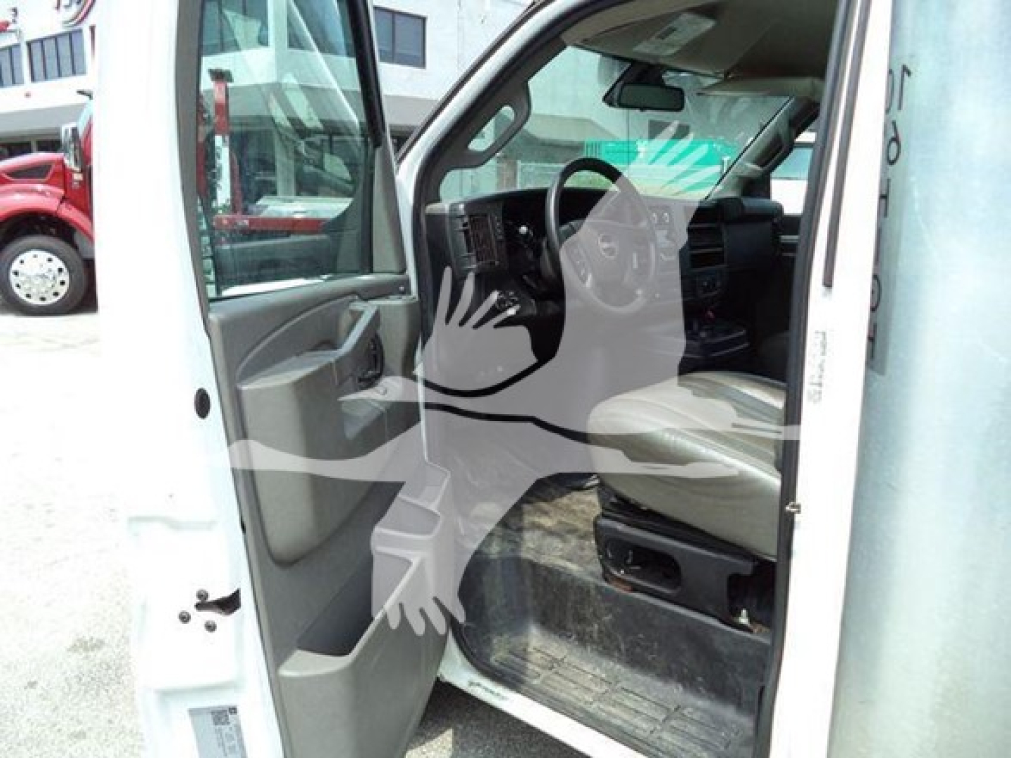 GMC G3500 cab interior showing driver seat and open door, front dash and steering wheel visible.