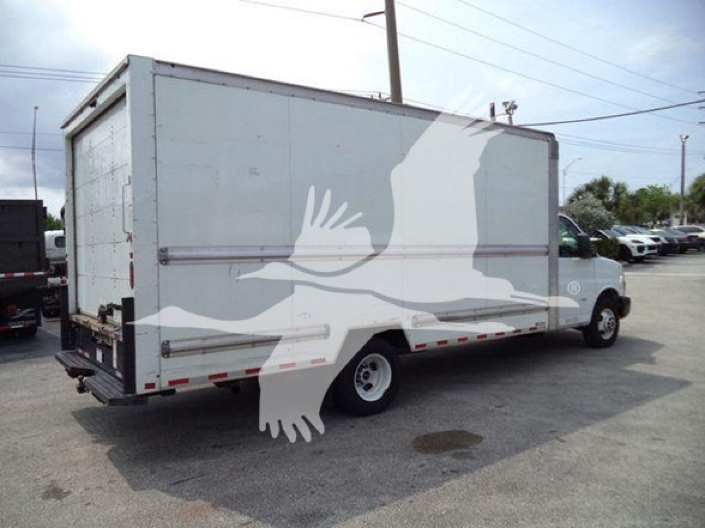 Box truck rear and side view showing cargo box with latching doors and rear bumper, GMC G3500 likely medium-duty box truck, used vehicle.