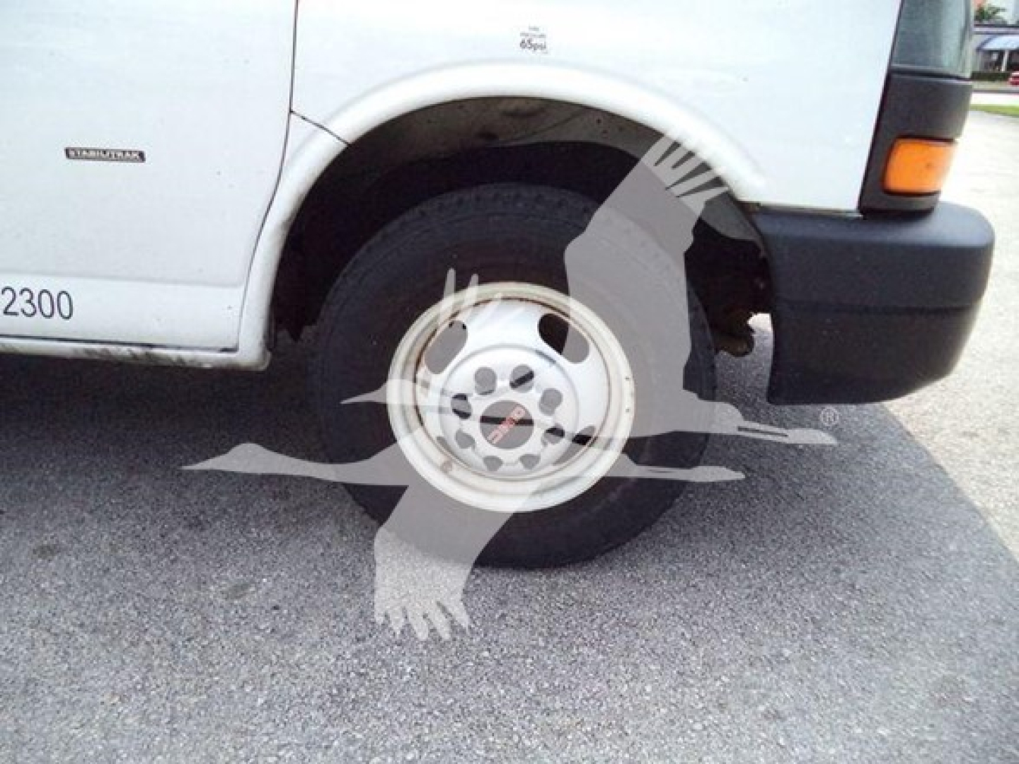 Truck wheel close-up on a 2021 GMC G3500 listing showing front left wheel and fender with body tag and side badge