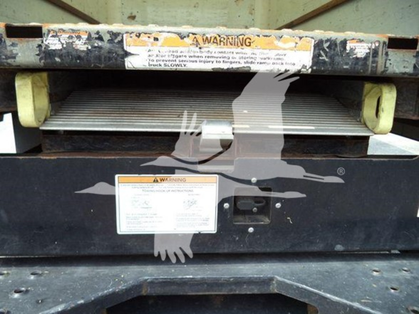 Warning label and control panel on a GMC G3500 cutter/roller mechanism. Visible text includes a warning label and instruction placard with small, unreadable print.
