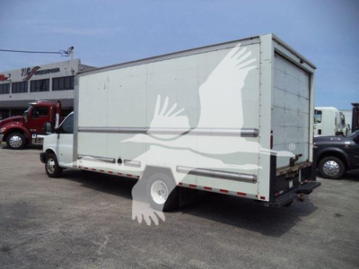 Box truck with white cargo body and rear roll-up door, side letterings with graphic of flying birds and crane-like shapes. Subtle diamond plate rails along sides.