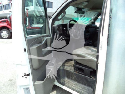 GMC G3500 cab interior showing driver seat and open door, front dash and steering wheel visible.