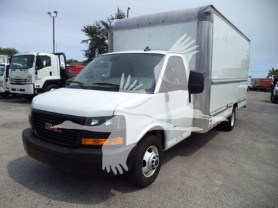 GMC 3500 cargo box truck in a side-front view showing cab and large box rear, white with black front bumper and orange turn signals.