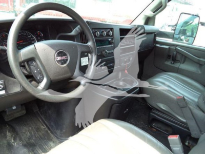 GMC G3500 interior view showing steering wheel, dashboard, and front seats; right-hand passenger seat visible; standard gauge cluster and center console.