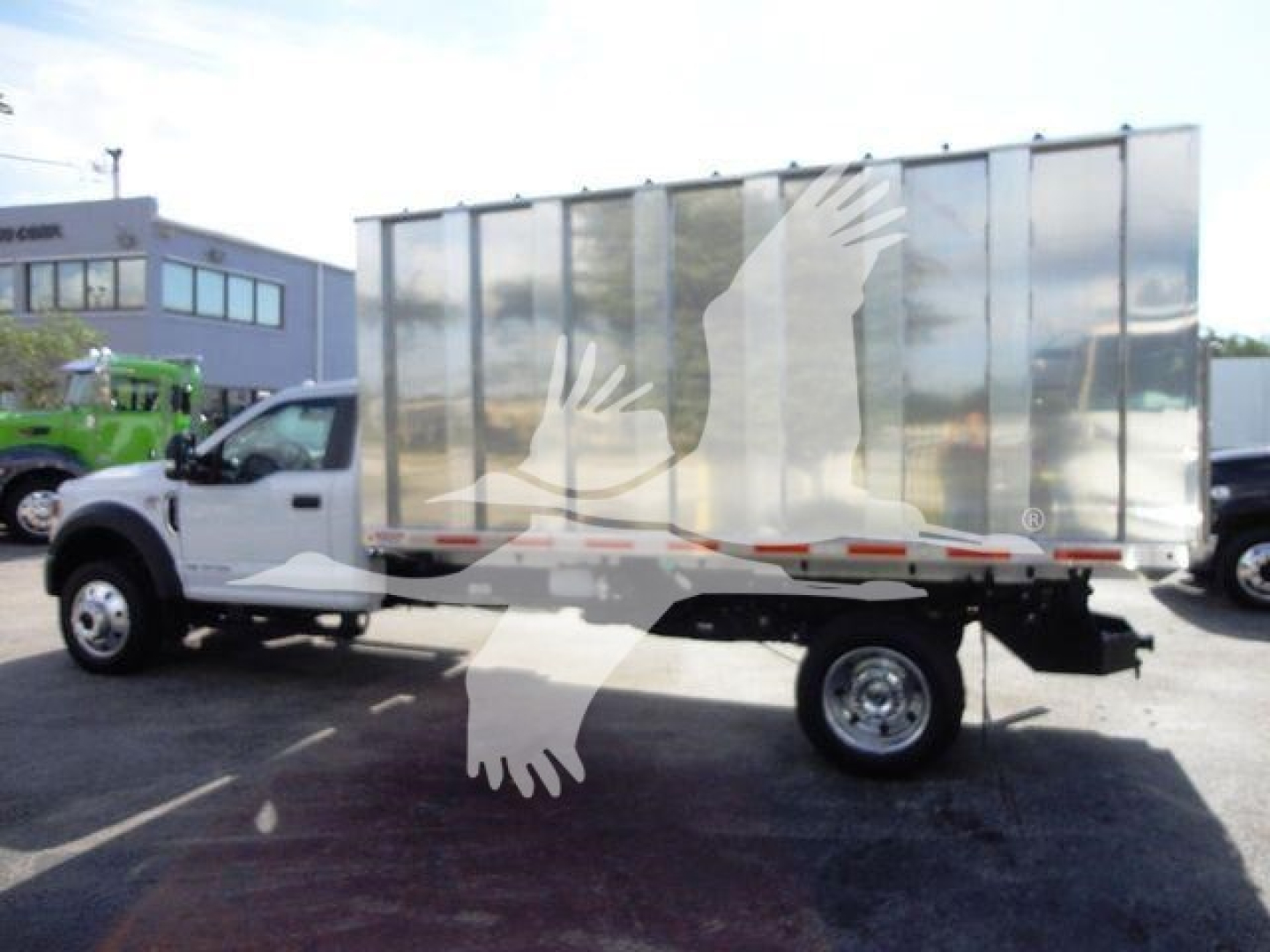 Ford F550 dump truck with chrome dump body, side view showing chassis and single rear wheel.