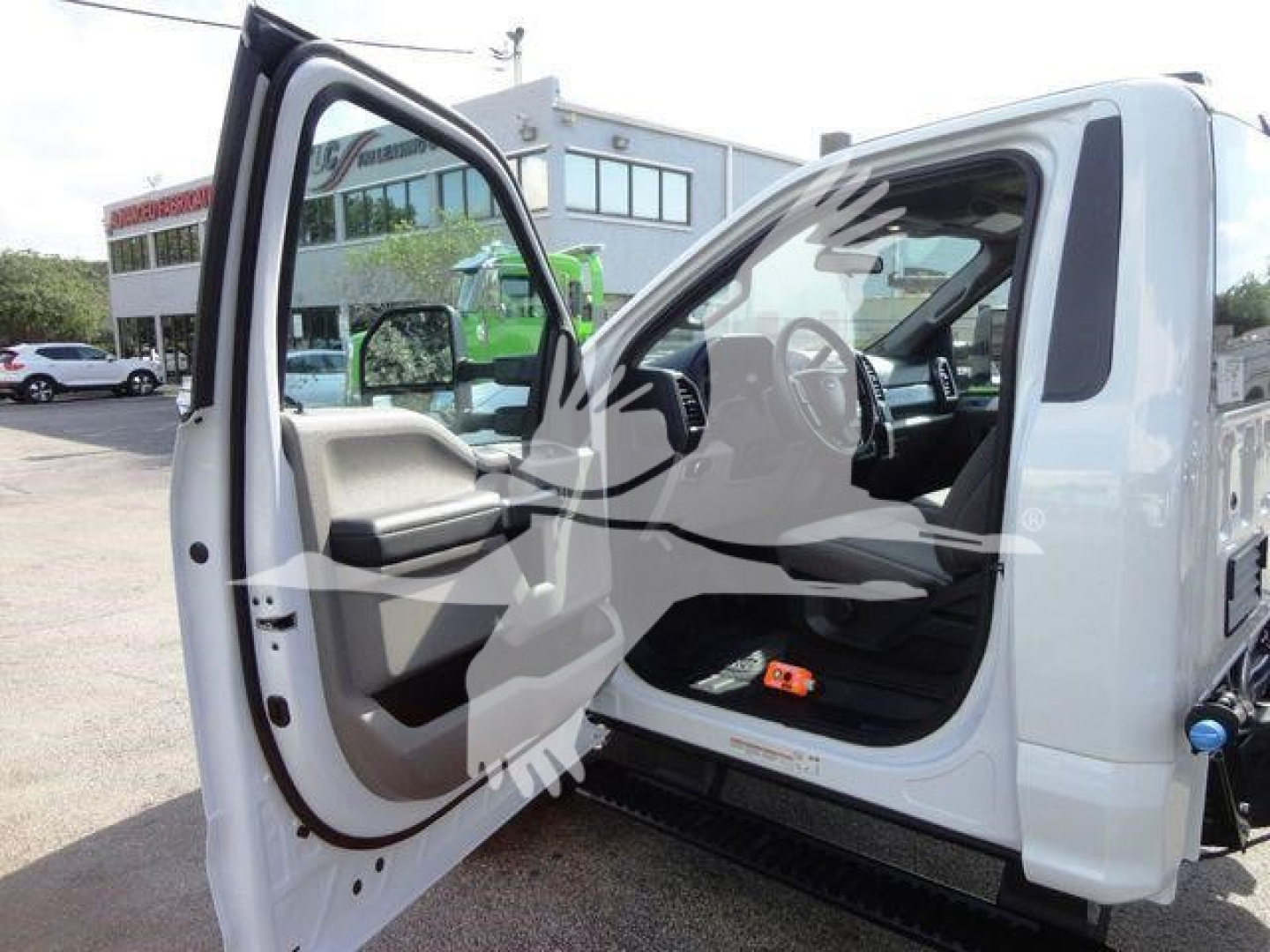 Ford F-550 dump truck cab interior with driver door open showing steering wheel, dashboard, and passenger seat.