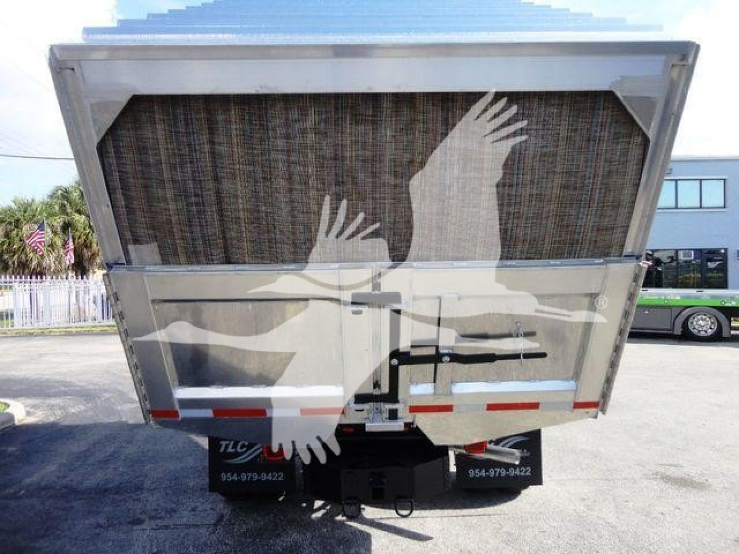 Ford F550 dump truck rear showing large dump bed, tailgate, and hitch with service decals.