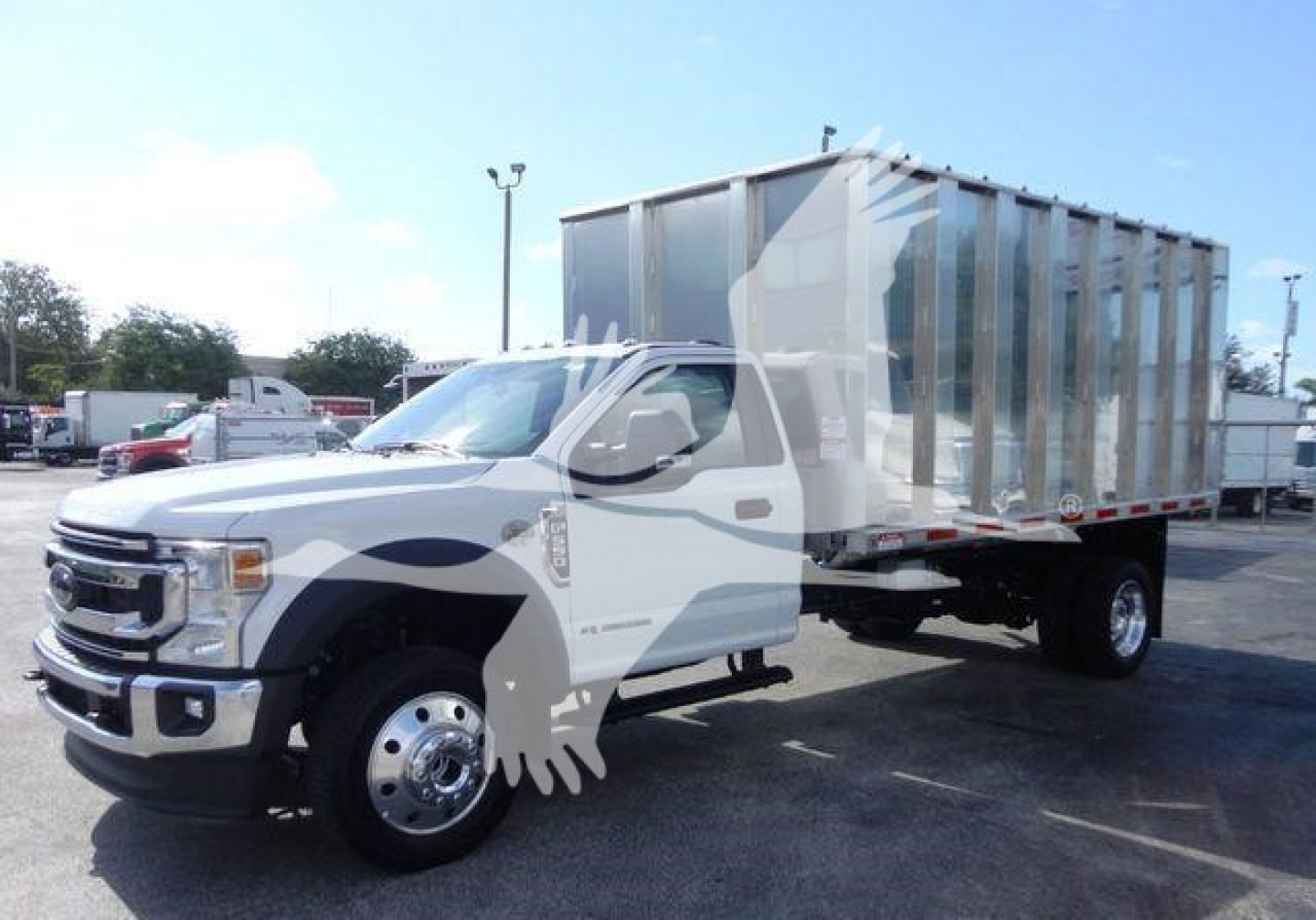 Ford F-550 dump truck with stakeside dump bed and white cab, front-left view, stock number F5504X4CHIPPER.