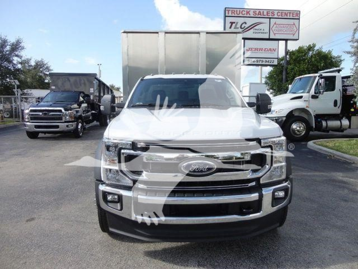 Ford F-550 in front view showing chrome grille and Ford emblem; front bumper; large towing mirrors; truck lot in background.