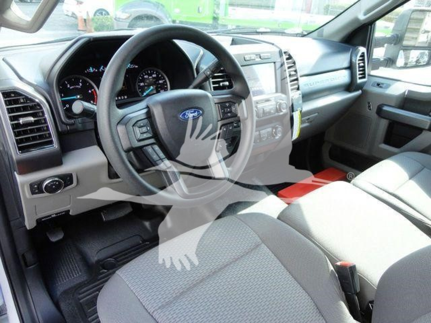 Ford F-550 interior front cabin showing steering wheel, instrument cluster, center console, and front seats.